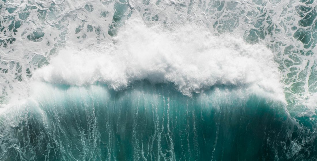 Beautiful,Aerial,View,Of,A,Wave,Crashing,In,A,Blue